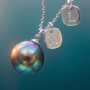 Detail of a dark pearl and silver initial charms